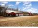 Large barn with multiple garage doors and a charming red building at 223 Scottish Dr, Mooresville, NC 28115