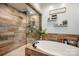 Bathroom featuring soaking tub, glass shower, and decorative wood accent wall at 223 Scottish Dr, Mooresville, NC 28115