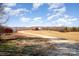 Expansive farm property featuring a well-manicured lawn, clear skies, and rustic-red buildings at 223 Scottish Dr, Mooresville, NC 28115