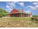 Charming red farmhouse with wraparound porch and well-manicured lawn at 223 Scottish Dr, Mooresville, NC 28115