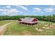 Stunning red barn-style home boasts a metal roof, spacious porch, and beautifully landscaped yard, perfect for country living at 223 Scottish Dr, Mooresville, NC 28115