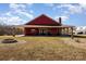 Charming red home featuring a covered porch and a stone fire pit in the front yard at 223 Scottish Dr, Mooresville, NC 28115