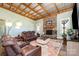 Inviting living room featuring a stone fireplace, wood-beam ceiling, and plush seating at 223 Scottish Dr, Mooresville, NC 28115