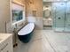 Elegant bathroom with a standalone tub, glass shower, and marble countertops at 2702 Occaneechi Ct, Waxhaw, NC 28173