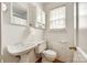 All-white bathroom featuring a pedestal sink, toilet, and built-in storage at 315 Wakefield Dr, Charlotte, NC 28209