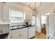 Bright kitchen featuring white cabinets, stainless steel sink, window, and modern lighting at 315 Wakefield Dr, Charlotte, NC 28209