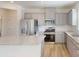 Modern kitchen with stainless steel appliances, grey cabinets, granite countertops, and light wood flooring at 4005 Lawnview Dr, Charlotte, NC 28269