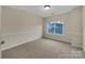 Well-lit carpeted bedroom featuring a large window that lets in plenty of natural light at 5002 Fine Robe Dr, Indian Trail, NC 28079