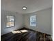 Bedroom featuring laminate flooring, white walls and trim, and two windows at 502 E Maine Ave, Bessemer City, NC 28016