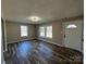 Spacious living room with large windows, wood-look floors, and neutral paint at 502 E Maine Ave, Bessemer City, NC 28016