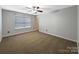 Bedroom featuring a large window with blinds, neutral walls and carpet, and a ceiling fan with a light fixture at 621 Ravenglass Dr, Fort Mill, SC 29715