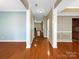 Inviting hallway with hardwood floors, neutral paint, crown molding, and a view of the living room at 621 Ravenglass Dr, Fort Mill, SC 29715