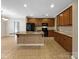 Spacious kitchen with tile floors, granite countertops, kitchen island, and wooden cabinets at 621 Ravenglass Dr, Fort Mill, SC 29715