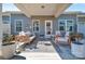 Covered back porch with neutral outdoor furniture including chairs and a loveseat at 6278 Ashton Park Dr, Denver, NC 28037