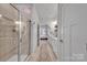 Modern bathroom with a glass enclosed shower, dual sinks, white cabinetry and decorative rug runner at 6278 Ashton Park Dr, Denver, NC 28037