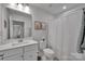 Bright bathroom featuring a white vanity, framed botanical prints, and a shower with a white curtain at 6278 Ashton Park Dr, Denver, NC 28037