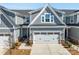 Two-story home with gray siding, brick accents, and a two-car garage with decorative windows at 6278 Ashton Park Dr, Denver, NC 28037