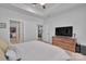 Bright main bedroom featuring a tray ceiling, ceiling fan, and a large dresser with a TV at 6278 Ashton Park Dr, Denver, NC 28037