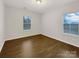 Bright bedroom with light walls, wood floors, and two large windows at 705 Old Cove Rd, Tega Cay, SC 29708