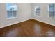 Neutral bedroom features hardwood floors and bright natural light from multiple windows at 705 Old Cove Rd, Tega Cay, SC 29708