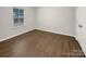 A cozy bedroom with wood floors, a window with blinds, and neutral-colored walls at 705 Old Cove Rd, Tega Cay, SC 29708
