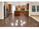 Spacious kitchen features stainless steel appliances, center island, wooden cabinets, and wood flooring at 705 Old Cove Rd, Tega Cay, SC 29708