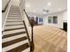 Inviting living room with staircase, neutral carpet, fireplace, and open view into modern kitchen at 705 Old Cove Rd, Tega Cay, SC 29708