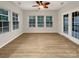 Bright sun room with three large windows, light wood flooring, and access to back porch at 705 Old Cove Rd, Tega Cay, SC 29708