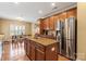 Kitchen with granite island, wood cabinets, stainless steel refrigerator, and adjacent dining area at 806 Irish Green Dr, Clover, SC 29710