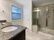 Well-appointed bathroom with granite countertops, a glass-enclosed shower, and a window at 8619 Harris Lake Ln, Charlotte, NC 28269