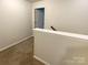 Upstairs hallway with carpet, a white banister and a gray wall paint at 8619 Harris Lake Ln, Charlotte, NC 28269