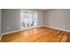 Bright bedroom with hardwood floors and a view of the porch through large window at 9026 Longview Dr, Charlotte, NC 28214