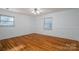 Bright bedroom featuring hardwood floors, ceiling fan, and natural light from two windows at 9026 Longview Dr, Charlotte, NC 28214