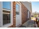Exterior view of brick home featuring a white door and a small covered porch at 9026 Longview Dr, Charlotte, NC 28214