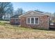 Back exterior of brick house showing windows, siding, and yard with mature trees at 9026 Longview Dr, Charlotte, NC 28214