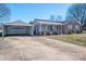 Ranch-style brick and siding home with solar panels, detached garage and long driveway on sunny day at 9026 Longview Dr, Charlotte, NC 28214