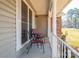 Welcoming front porch featuring chairs, a small table, and a decorative railing at 9026 Longview Dr, Charlotte, NC 28214