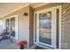Inviting front porch with a glass door, window, potted flowers and outdoor seating area at 9026 Longview Dr, Charlotte, NC 28214