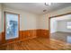 Cozy living room featuring wood-panel walls, hardwood floors, and natural light at 9026 Longview Dr, Charlotte, NC 28214