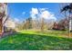 Expansive green backyard featuring mature trees and partial fencing, perfect for recreation and relaxation at 9220 Torrence Crossing Dr, Huntersville, NC 28078