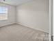 Bright bedroom with neutral carpet and large window allowing natural light at 11142 Jc Murray Nw Dr, Concord, NC 28027