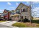 View of the townhome featuring a two-car garage and well-maintained landscaping at 11142 Jc Murray Nw Dr, Concord, NC 28027