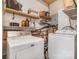 Functional laundry room with side-by-side washer and dryer, and overhead shelving for storage at 127 Wright Cir, Cherryville, NC 28021