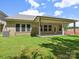 Expansive backyard featuring a brick home, green grass, and a covered patio space at 13134 Macon Hall Dr, Mint Hill, NC 28227