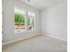 Bright bedroom with neutral carpet and views of the partially landscaped yard at 13134 Macon Hall Dr, Mint Hill, NC 28227