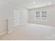 Bright bedroom featuring neutral walls, carpet and trim, and natural light from the windows at 13134 Macon Hall Dr, Mint Hill, NC 28227
