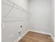 Laundry room with wooden floor, wire shelving, and utility connections at 13134 Macon Hall Dr, Mint Hill, NC 28227
