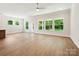 Large living room featuring many windows with backyard views and hardwood floors at 13134 Macon Hall Dr, Mint Hill, NC 28227