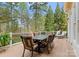 Inviting outdoor deck with dining table and chairs plus lounge chairs overlooking mature trees at 132 Tuskarora Point Ln, Mooresville, NC 28117