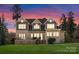 Stunning home exterior with a well-manicured lawn, deck, neutral paint, and a beautiful sunset backdrop at 132 Tuskarora Point Ln, Mooresville, NC 28117